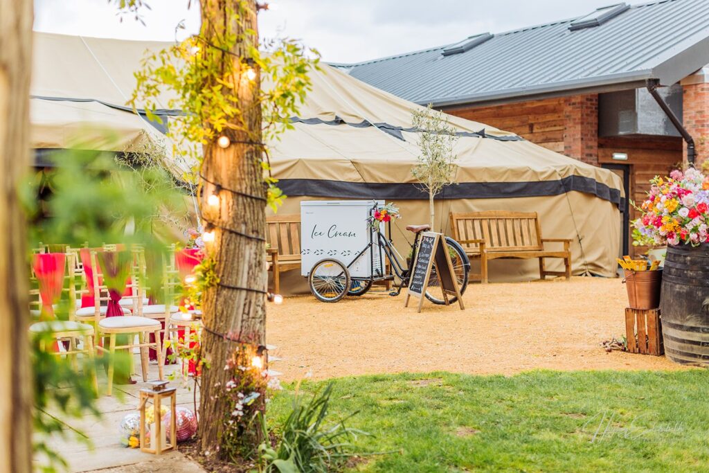Bennetts willow barn wedding yurt marquee with an ice cream bike outside the entrance and ceremony seating can be seen to the left of the image