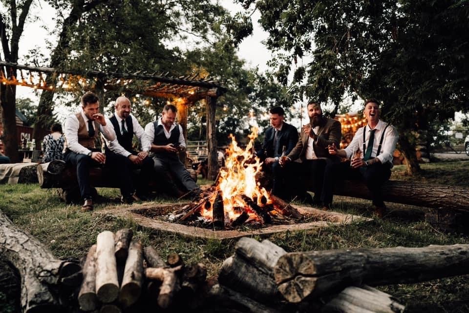 Wedding guests sat around a fire pit at Bennets Willow Barn